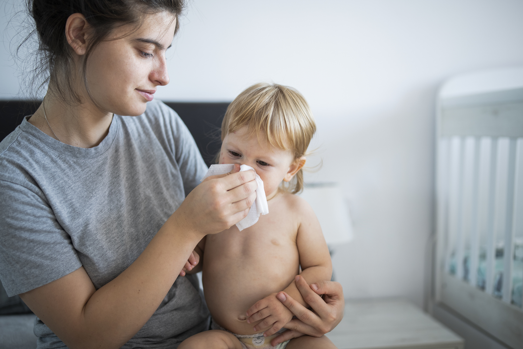 Loving mother blowing her toddler’s nose. Workshop de emergência pediátrica